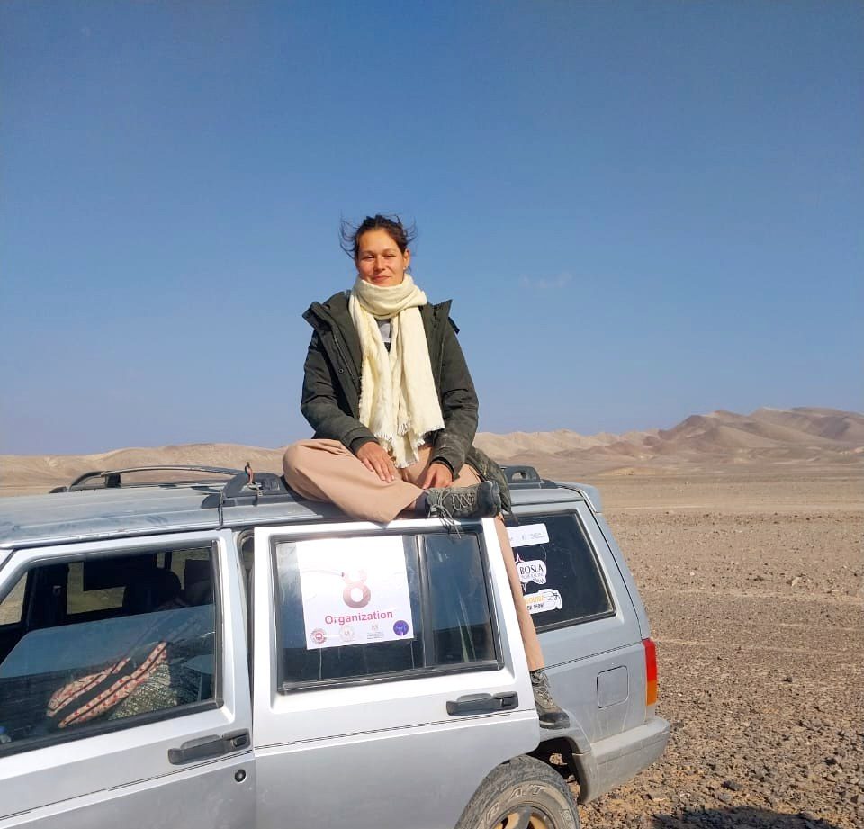 Nikita sitting on top of a jeep in the Moroccan desert