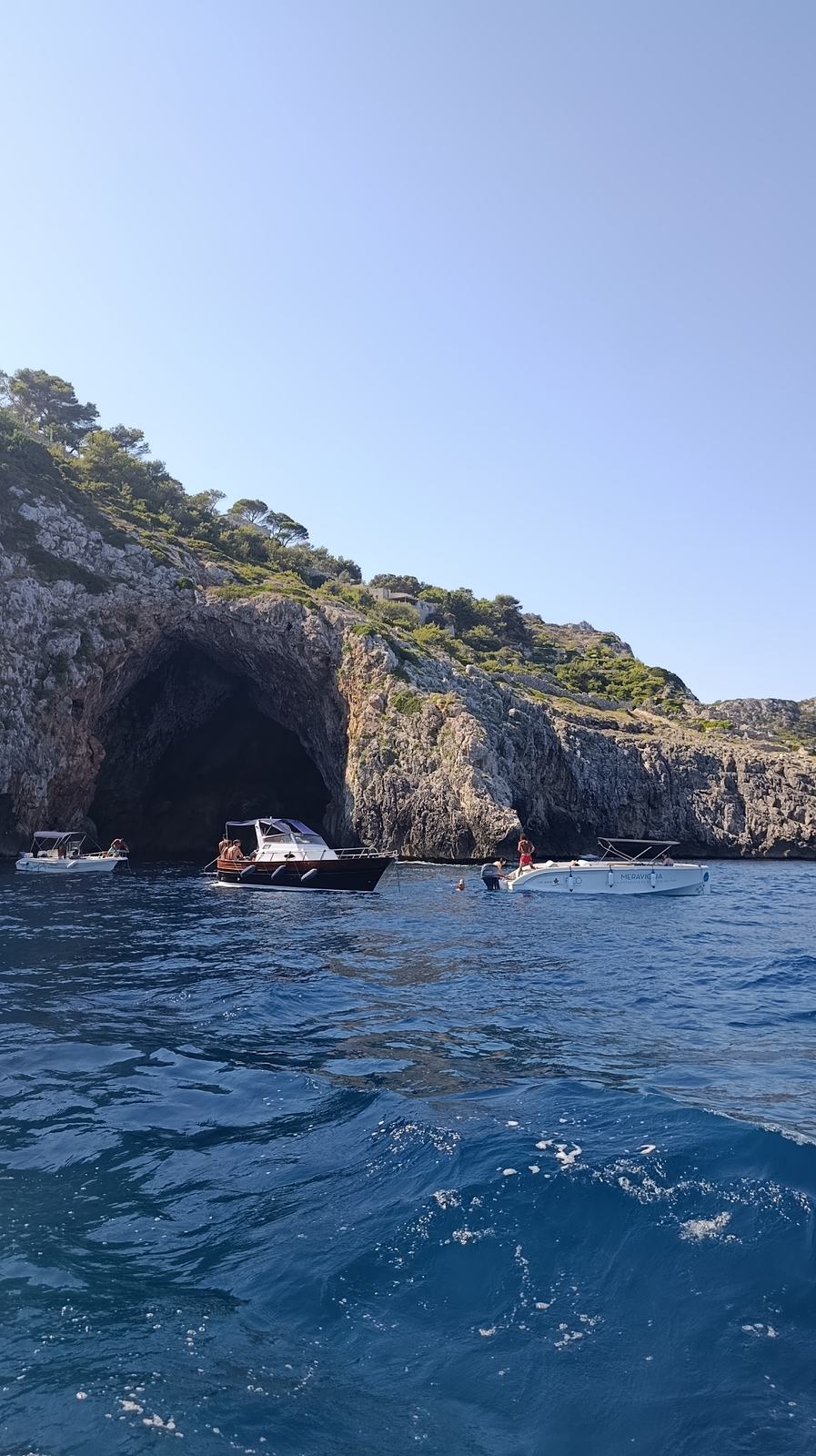 Boats gathered at the entrance of Grotta del Laghetto sea cave near Santa Maria di Leuca