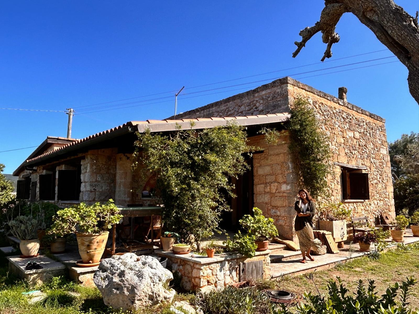 Nikita in front of the stone house of Il Sentiero in the sun