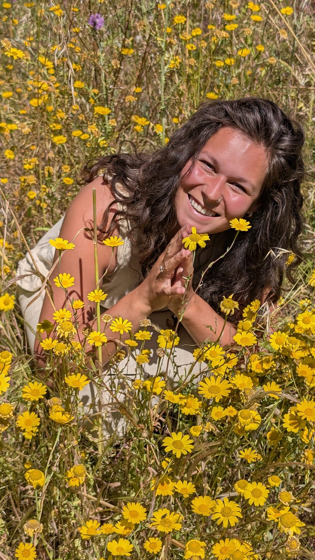 Nikita laughing in yellow wildflowers in Salento Puglia