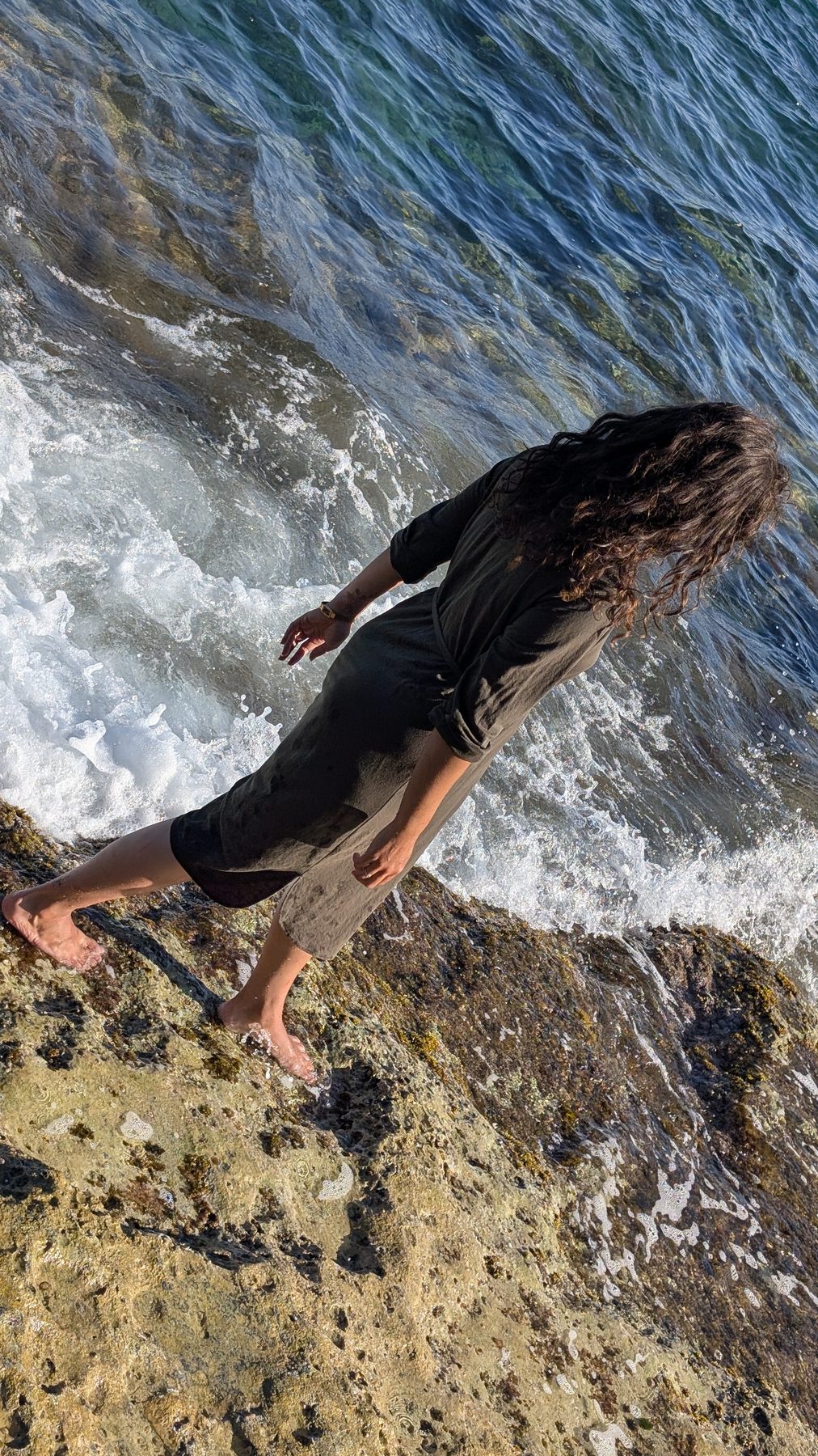 Nikita walking on Salento rocks by the sea viewed from above