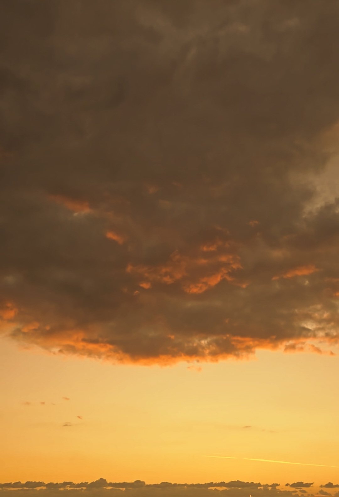 Dark clouds edged with gold above the Salento horizon
