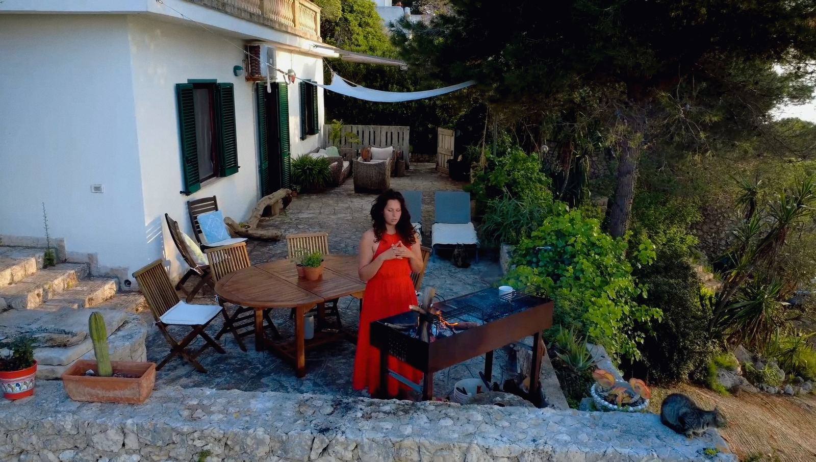 Nikita accanto al fuoco sul terrazzo di Il Sentiero la sera, Salento