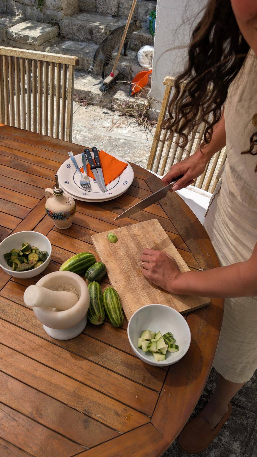Mani che preparano verdure fresche sul tavolo del terrazzo