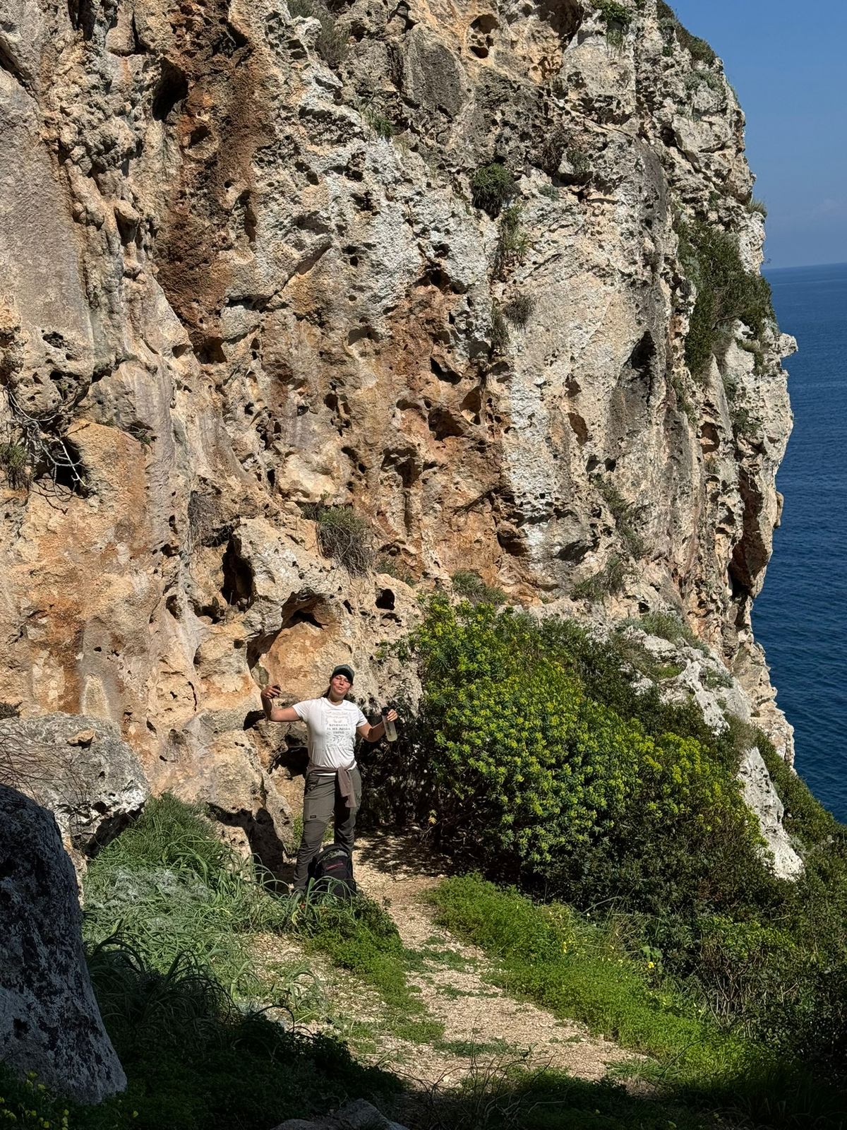 Hiker at the base of the Salento cliffs along the coastal path, Puglia